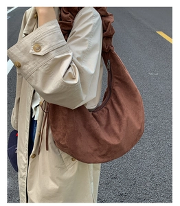 Detail of dark brown faux suede hobo bag with scrunched shoulder strap and zipper closure