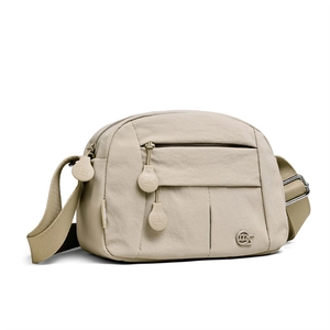 Detail view of khaki crossbody bag with multi-layer zipper pockets and adjustable strap