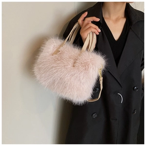 Detail of plush pink faux fur texture and beige PU leather straps on a crossbody handbag