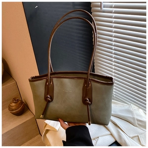 Detail of vintage olive green tote bag featuring matte texture and deep brown knotted straps