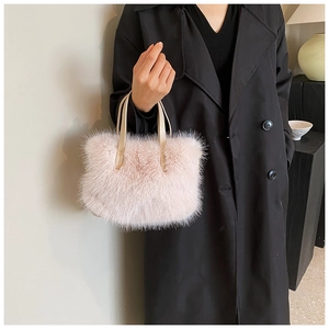 Close-up of soft pink plush handbag with leather handle and fluffy faux fur texture