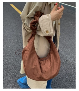 Brown suede hobo bag with cloud-pleated shoulder strap and rounded half-moon silhouette