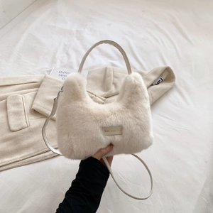 Detail of white faux fur crossbody bag featuring a love every day label and silver hardware