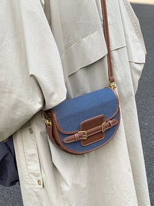 Retro patchwork saddle bag in blue denim and brown leather worn crossbody by model