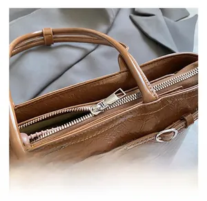 Detail of glossy wrinkled leather bag with premium silver zipper and metallic hardware