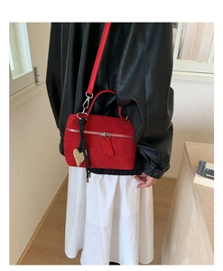 Détail du mini sac barillet en daim rouge avec breloque cœur dorée et double fermeture