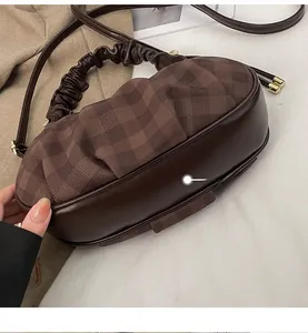 Detail showing the reinforced thickened bottom and premium textured stitching on the brown bag