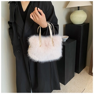 Detail of pink faux fur handbag showing soft texture and cream leather handles