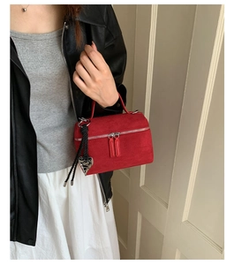 Détail du mini sac carré en daim rouge avec pendentif coeur et double fermeture