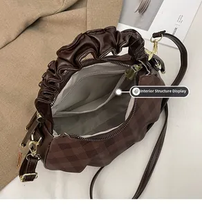 Interior structure of coffee pleated crossbody bag showing zipper pocket and lining