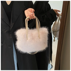 Detail shot of the long fluffy faux fur texture on a light pink plush handbag