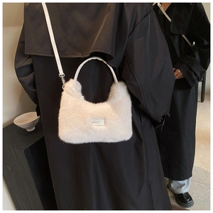 Detail of white fluffy plush handbag featuring love every day tag and leather handle
