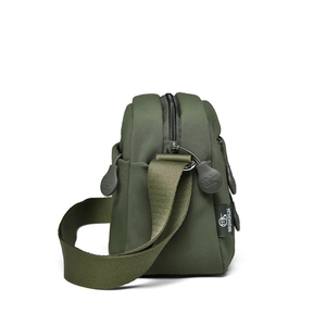 Detail of olive green nylon bag showing multi-layered compartments and soft rubber zippers