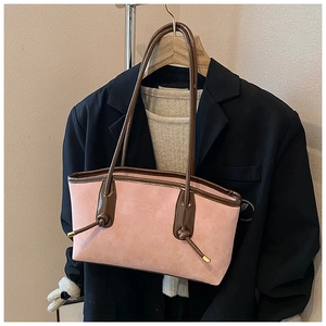 Detailed close-up of pink suede tote bag with brown leather handles and knot accents