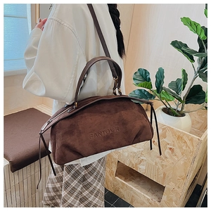 Detailed view of brown suede satchel featuring stylish long fringe tassels and side zipper