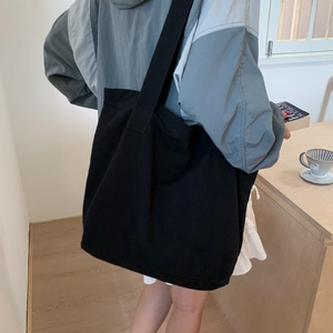 Spacious black canvas tote bag shown on model for daily commuting and shopping use