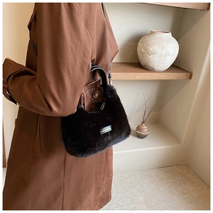 Detail of black plush faux fur bag featuring love every day label and leather strap