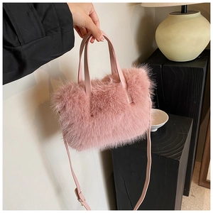 Detailed close-up of a pink faux fur handbag with soft texture and golden metal hardware