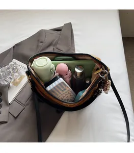 Detail view showing large interior capacity of brown suede bag with daily essentials