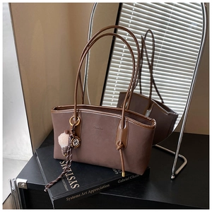 Detail view of large dark brown tote bag with thin straps and ice cream charm decoration