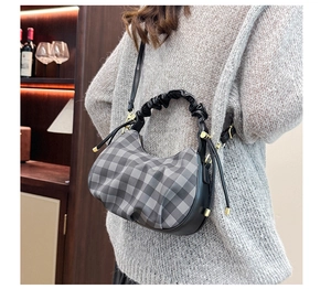 Detail of checkered plaid dumpling bag with ruffled handle and adjustable shoulder strap