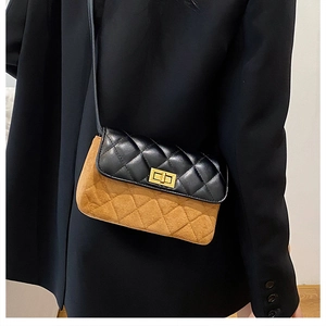 Detail of a vintage quilted crossbody bag with a golden turn-lock and mixed texture leather