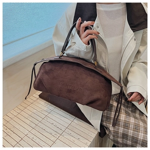 Detail of coffee brown suede Boston bag with embossed logo and retro zipper strap design