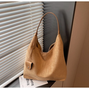 Detail view of large camel suede hobo bag with a decorative buckle strap and soft texture