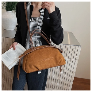 Detail of vintage brown suede Boston bag with embossed logo and dual top handles