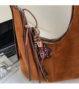 Sac hobo en daim marron avec breloques décoratives et finition texturée vintage