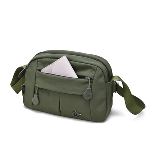 Close-up of army green crossbody bag with multiple zipper compartments and waterproof fabric