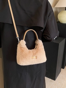 Stylish khaki faux fur dumpling bag with crossbody strap shown on a model in trench coat