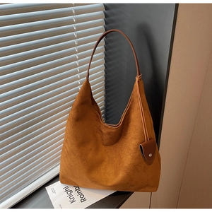 Detailed close-up of premium brown faux suede hobo bag texture and elegant side drawstring