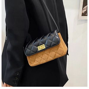 Model wearing a retro quilted crossbody bag in black and brown with a gold clasp