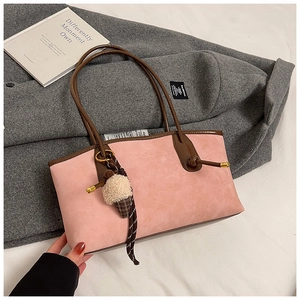 Pink suede tote bag with brown leather handles and cute ice cream charm on a coat