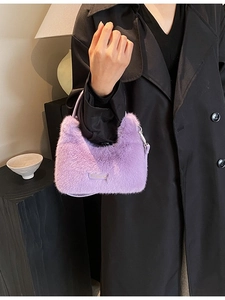 Fashionable lavender faux fur crescent bag worn by model over a black stylish coat