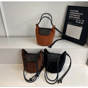 Trois sacs seau minimalistes en daim givré de couleur orange-brun, marron foncé et noir