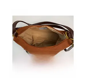 Detailed view of the brown suede handbag interior with fabric lining and leather strap