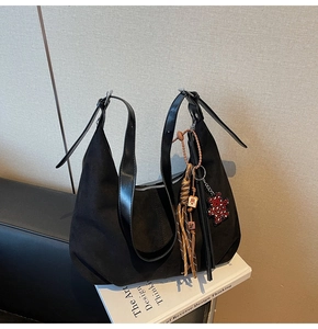 Détail du sac hobo en daim noir avec bandoulière réglable et breloque ours coeur léopard