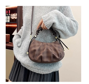 Detail of checkered hobo bag with pleated handle and golden hardware on grey sweater