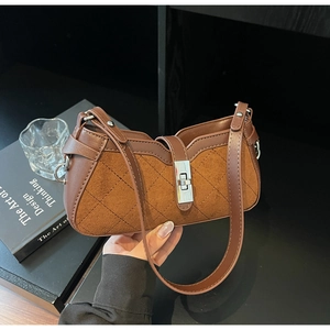 Dettaglio della borsa patchwork marrone con cuciture in pelle e chiusura rotante