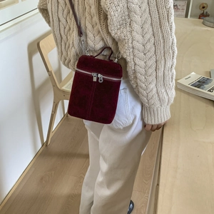 Detail of burgundy frosted leather mini crossbody bucket bag with silver zipper