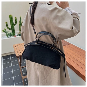 Detail of black suede Boston bag with PANTOOR embossed logo and leather handle