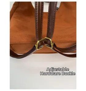 Detail of brown matte suede bag strap with adjustable golden metal buckle and hardware