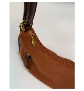 Detail of vintage bronze zipper and premium brown suede material on women shoulder bag