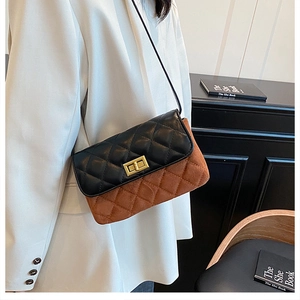 Detail of quilted crossbody bag with two-tone design and gold twist lock closure