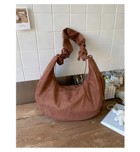 Detail view of brown faux suede hobo bag with trendy pleated ruffle shoulder strap design