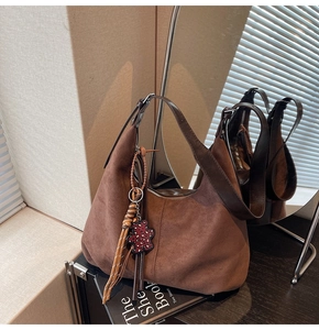 Détail du sac hobo en daim marron avec bandoulière cuir et breloque ours léopard