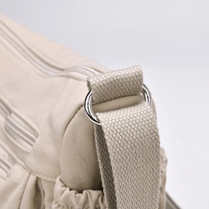 Detailansicht der Nylon-Umhängetasche mit silbernen Metallringen und robustem Gurtband