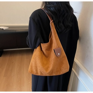 Detail of caramel suede hobo bag with wide strap and matching decorative leather pouch